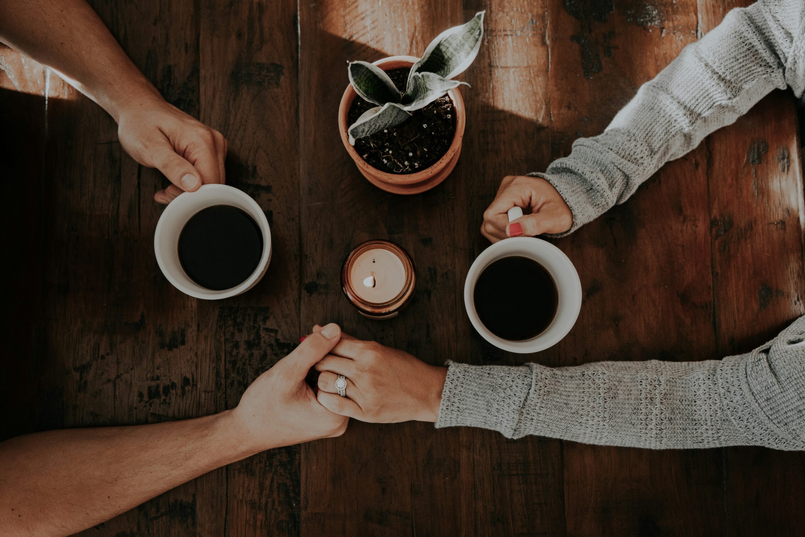 Couple holding hands over coffee