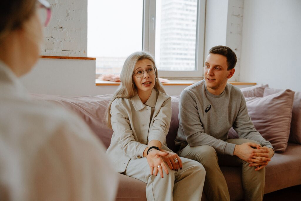 A couple and therapist engaged in a discussion during a therapy session indoors